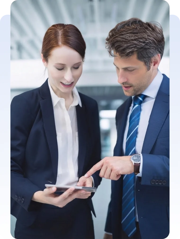 Two business professionals reviewing information together on a tablet.